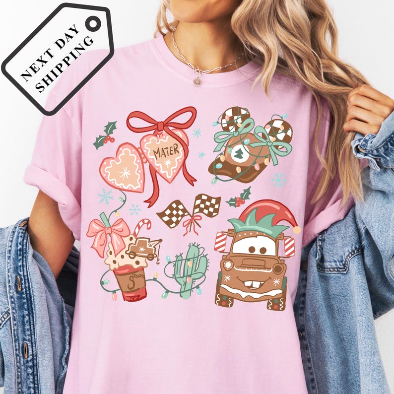 A person wearing a pink t-shirt with various Christmas-themed illustrations, including a character, a snowman, and other festive elements.