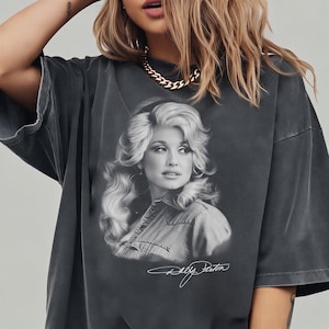 A woman wearing a black t-shirt with a portrait of a woman printed on it.