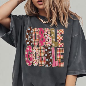 A woman wearing a gray t-shirt with the text "GOBBLE GOBBLE" printed on it.