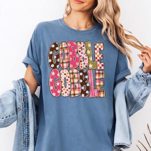 A woman wearing a blue t-shirt with the text "GOBBLE GOBBLE" printed on it.