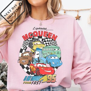 A pink sweatshirt with a graphic of characters from the animated movie "Cars".