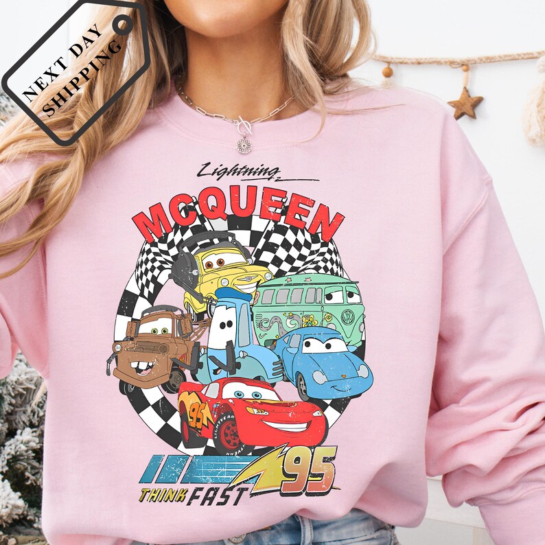 A pink sweatshirt with a graphic of characters from the animated movie "Cars".