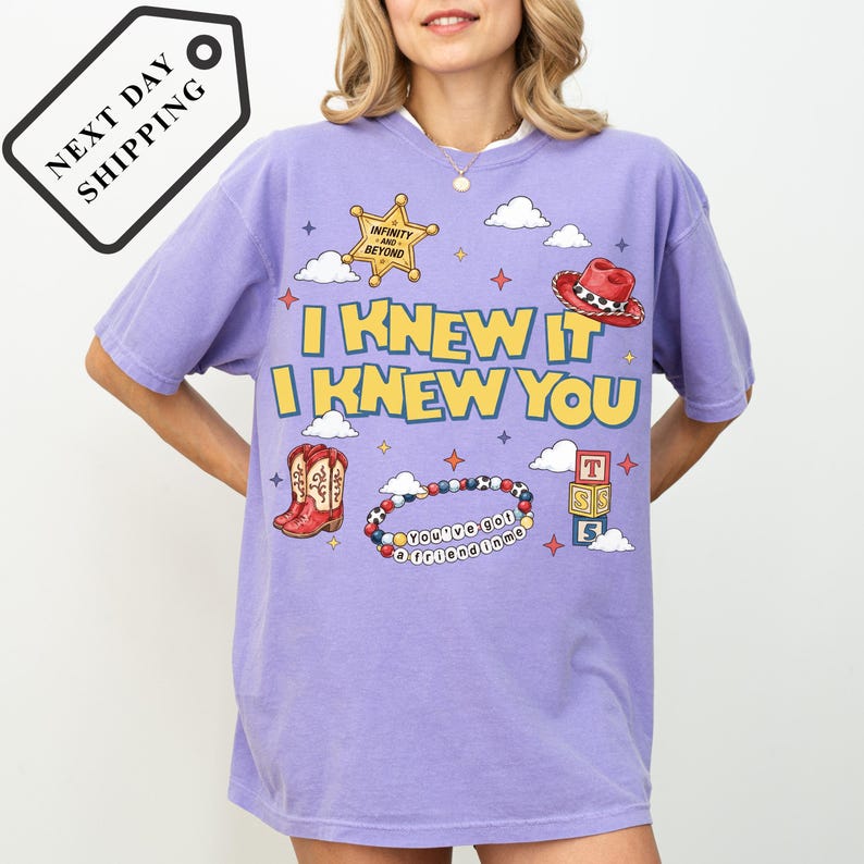 A woman wearing a purple t-shirt with a cartoon-style design and text.