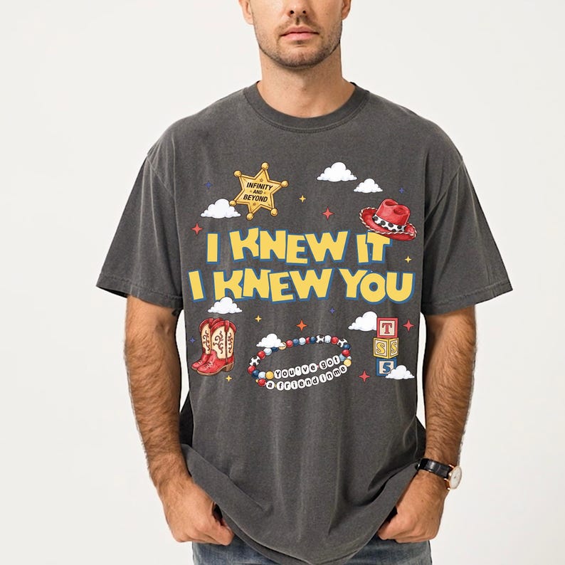 A man wearing a gray t-shirt with a graphic design featuring various cartoon-style icons and text.