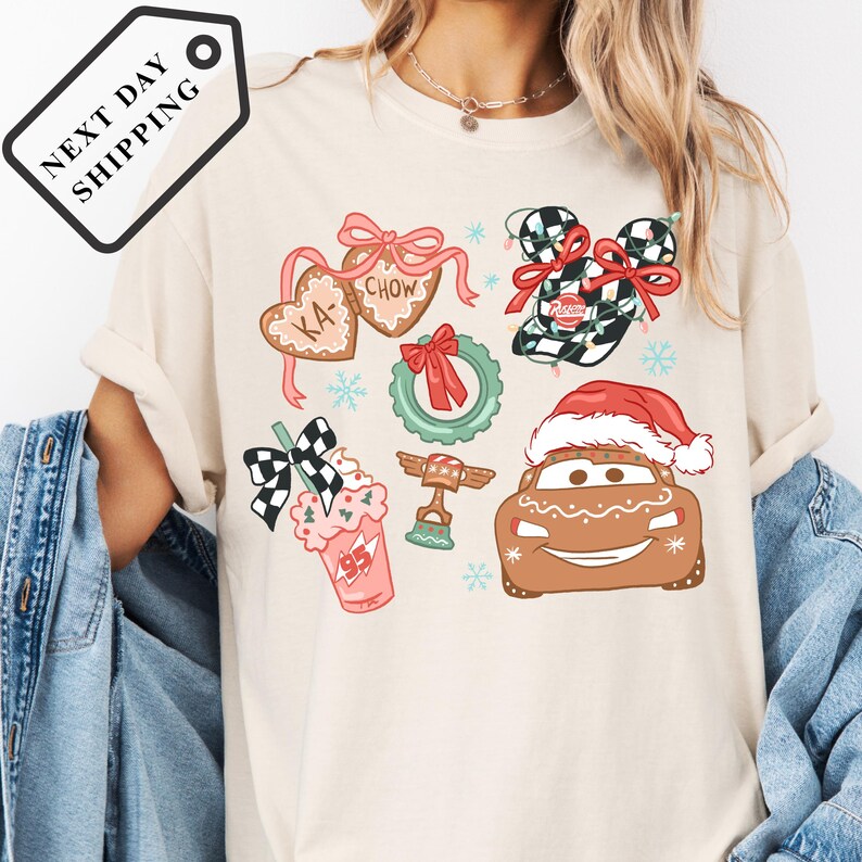 A person wearing a white t-shirt with various Christmas-themed illustrations, including a Santa hat, a gingerbread man, and other festive decorations.