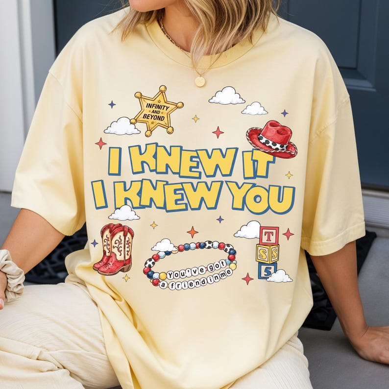 A person wearing a yellow t-shirt with a cartoon-style design and text printed on it.