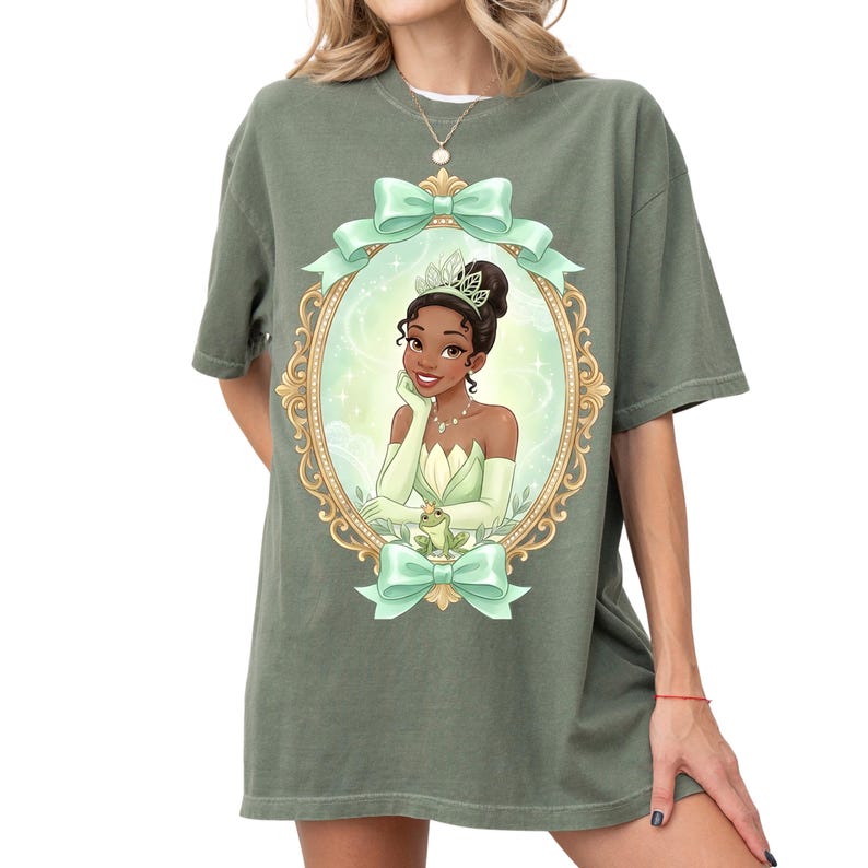 A woman wearing a green t-shirt with a graphic of a princess in a green dress and crown.