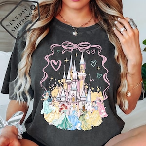 A woman wearing a black t-shirt with a Disney princess castle graphic printed on it.