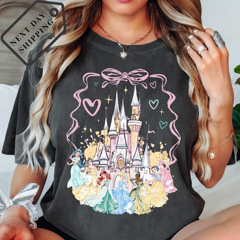 A woman wearing a black t-shirt with a Disney princess castle graphic printed on it.