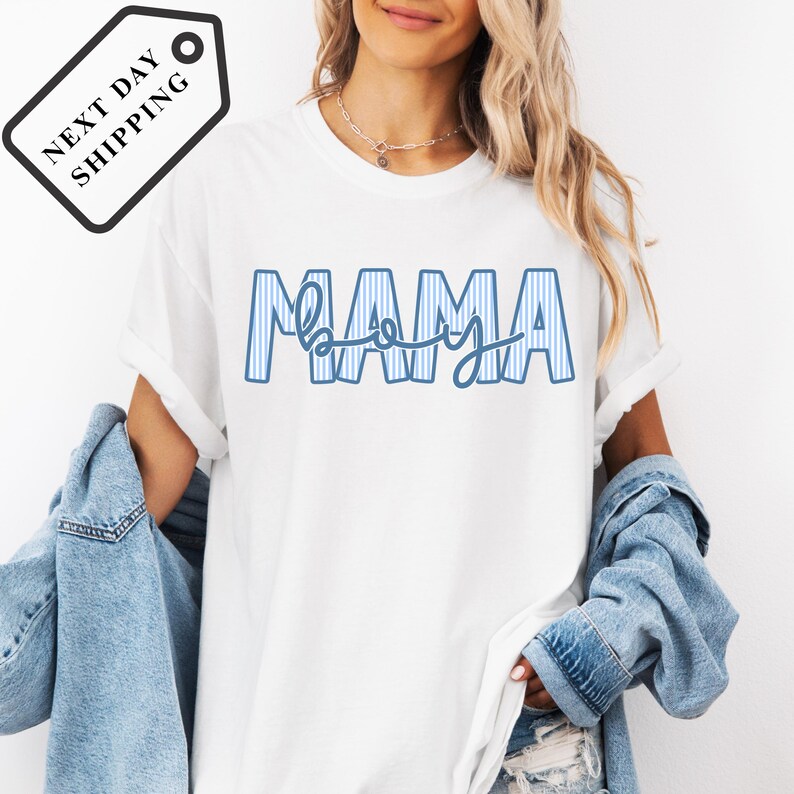 A woman wearing a white t-shirt with the word "MAMA" printed on it, along with a denim jacket.