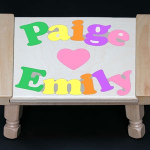 Personalisierter Puzzle Hocker mit 2 Namen in Pastellfarben mit einem Herz oder Schmetterling. Ein Lernpuzzle für Kleinkinder im Vorschulalter, um ihre 2 Namen zu lernen.