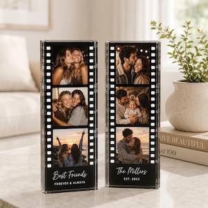 Può includere: Due blocchi portafoto verticali in acrilico trasparente progettati come strisce di pellicola. Ogni blocco mostra tre foto quadrate e testo personalizzato in basso. Il blocco sinistro riporta Best Friends FOREVER & ALWAYS, quello destro The Millers EST. 2022.