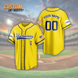 May include: Yellow baseball jersey with navy blue trim and the word "Bananas" in script. The jersey has the number 1 on the front and the American flag on the sleeve. The back of the jersey has the text "YOUR NAME" and the number 00.