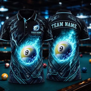 May include: A black polo shirt featuring a graphic of a number 9 billiard ball surrounded by bright blue flames. The front includes the text YOUR NAME and a small 9 ball icon, while the back displays the text TEAM NAME in a bold font.