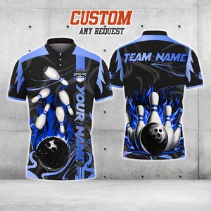 Puede incluir: Camiseta de bolos negra y azul con un diseño personalizado. La camiseta presenta una bola y bolos con llamas azules y el texto "CUSTOM ANY REQUEST" en la parte superior. La parte delantera de la camiseta tiene el texto "YOUR NAME".