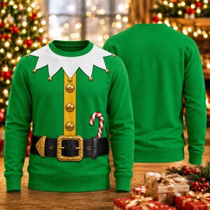 May include: A green long-sleeve sweatshirt featuring a printed elf costume design. The front displays a white jagged collar with gold bells, a vertical yellow stripe with gold buttons, a black belt with a gold buckle, and a red and white candy cane.