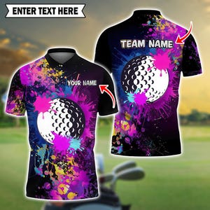 May include: Black golf polo shirt with a golf ball graphic and colorful paint splatter design. The shirt has the text "YOUR NAME" and "TEAM NAME" with the text "ENTER TEXT HERE" above the shirt.