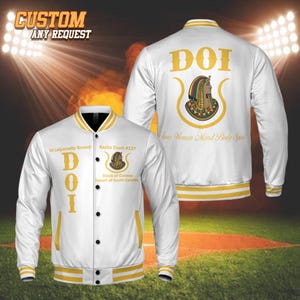 Könnte beinhalten: Weiße und goldene Collegejacke mit schwarzen Knöpfen. Auf der Vorderseite sind die Buchstaben "DOI" in Gold sowie Text und eine Grafik zu sehen. Auf der Rückseite sind "DOI" und eine Grafik abgebildet. Die Jacke hat goldene Streifen an Kragen, Manschetten und Saum.