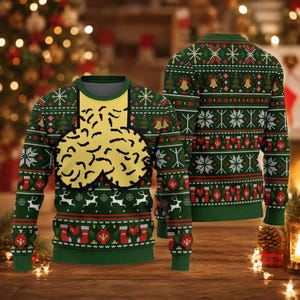 May include: A long-sleeve crew neck jumper in dark green featuring a repeating holiday pattern of white snowflakes, red stockings, and white reindeer. The front displays a large, yellow, textured graphic shape centred on the chest area.