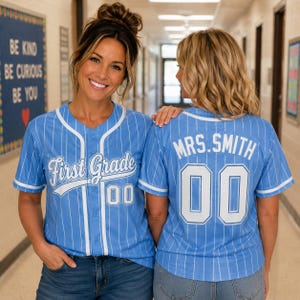 Könnte beinhalten: Ein hellblaues Baseballtrikot mit weißen Nadelstreifen und weißem Besatz. Die Vorderseite zeigt den Text First Grade und die Nummer 00. Die Rückseite zeigt den Text MRS. SMITH und die Nummer 00 in weißer Schrift auf dem hellblauen Stoff.