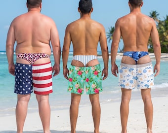 May include: Three pairs of swim trunks worn with matching thongs. The first pair features a blue and red American flag pattern with a pink leopard print thong. The second has a green tropical floral print with a white striped thong. The third has a blue and white seashell pattern with a blue camouflage thong.