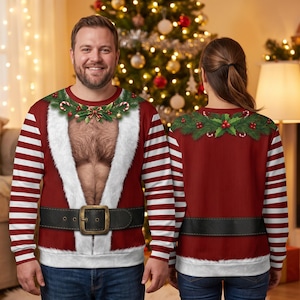Peut inclure: Un sweat-shirt à manches longues avec un motif rayé rouge et blanc sur les manches et une impression graphique d'un costume de Père Noël avec une ceinture noire, une bordure en fausse fourrure blanche et un torse poilu réaliste.