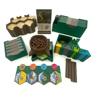 Peut inclure: Un jeu de société avec divers composants. Comprend des boîtes de rangement vertes, des tuiles hexagonales, des jetons en bois, une carte avec une image d'ours et un récipient en forme de souche d'arbre rempli de pommes de pin. Les pièces du jeu sont disposées sur une surface blanche.