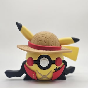 May include: A yellow Pikachu figurine wearing a straw hat with a red band, black glasses, and a red and black outfit. The figurine has black ears with black tips and a smiling face. The figure is a collectible item.