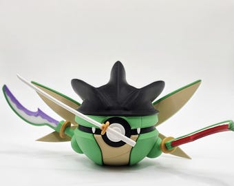 May include: A green and tan figurine with a black headpiece and white swords. The figurine has green wings and a white and black circular design on its front. The swords have red and purple accents.