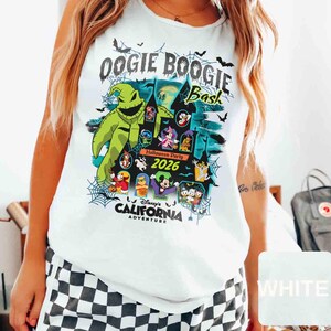 以下が含まれることがあります： ディズニー・カリフォルニア・アドベンチャーのOogie Boogie Bashハロウィーンパーティー2026のカラフルなグラフィックが特徴の白いタンクトップ。デザインには、ウギー・ブギーのキャラクター、コウモリ、その他のディズニーキャラクターが含まれています。
