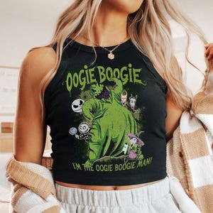 May include: Black tank top featuring a green graphic of Oogie Boogie from The Nightmare Before Christmas. The graphic includes other characters and the text "Oogie Boogie" and "I'm the Oogie Boogie Man!"