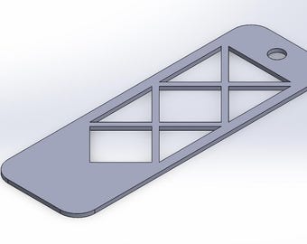 Op de afbeelding: Een zilveren metalen sleutelhanger met een uitgesneden geometrisch ontwerp. Het ontwerp bevat een reeks driehoeken en vierkanten.