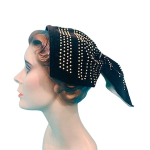 May include: A black velvet headband with gold-colored embellishments. The headband is tied in a knot at the back.