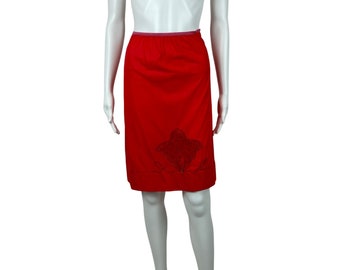 May include: A red knee-length slip skirt with a black embroidered floral design.