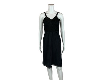 May include: A black slip dress with a lace trim. The dress has a fitted bodice and a flowing skirt.