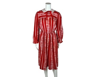 May include: A red and white striped dress with a white collar and a bow tie. The dress has long sleeves and a gathered waist.