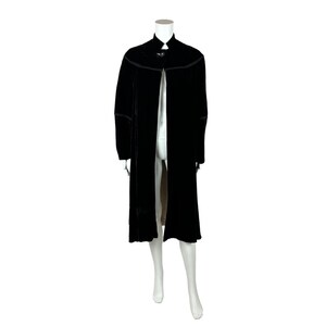 May include: A long black velvet cape with a high collar and a single button closure at the neck.