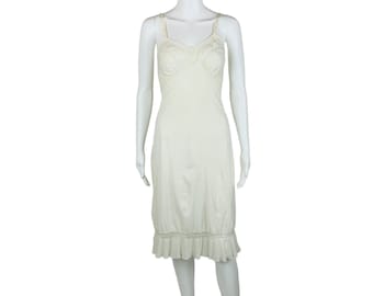 May include: A white slip dress with a lace trim around the neckline and hem. The dress has a fitted bodice and a flowing skirt.
