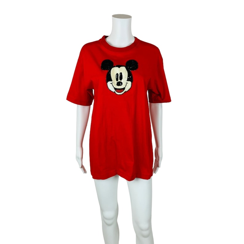 May include: Red short-sleeved t-shirt with a sequined Mickey Mouse design.