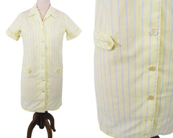 Puede incluir: Un vestido de manga corta a rayas amarillas y azules con cierre de botones en la parte delantera y dos bolsillos. El vestido tiene cuello.