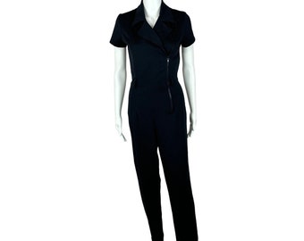 May include: A black short-sleeved jumpsuit with a zipper detail on the front. The jumpsuit has a collar and a relaxed fit.