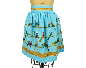 May include: A light blue skirt with a pattern of colorful birds on a wire fence. The skirt has a gold trim around the waist and hem.