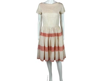 May include: A white lace dress with pink horizontal stripes around the skirt. The dress has a scoop neckline and short sleeves.