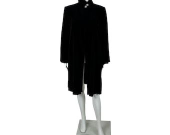 May include: A long, black velvet coat with a high collar and a decorative clasp. The coat is displayed on a mannequin against a white background. The coat's design is simple and elegant.