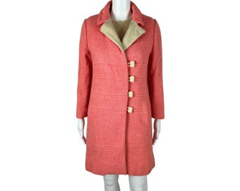 May include: A pink wool coat with a cream-coloured collar and five large cream-coloured buttons.