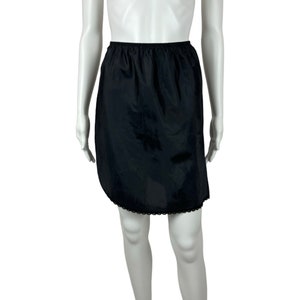 May include: A black slip skirt with a lace trim. The skirt is made of a smooth, silky fabric.