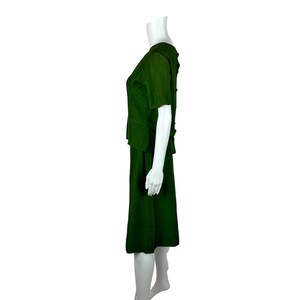 May include: A dark green skirt suit with a short-sleeved top and a knee-length skirt.