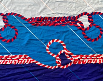 May include: Blue and white fabric with a red, white, and blue rope design. The fabric has a nautical theme.