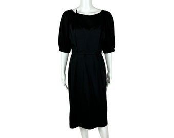 May include: A black midi dress with a bateau neckline and short puff sleeves. The dress has a fitted bodice and a slightly flared skirt.