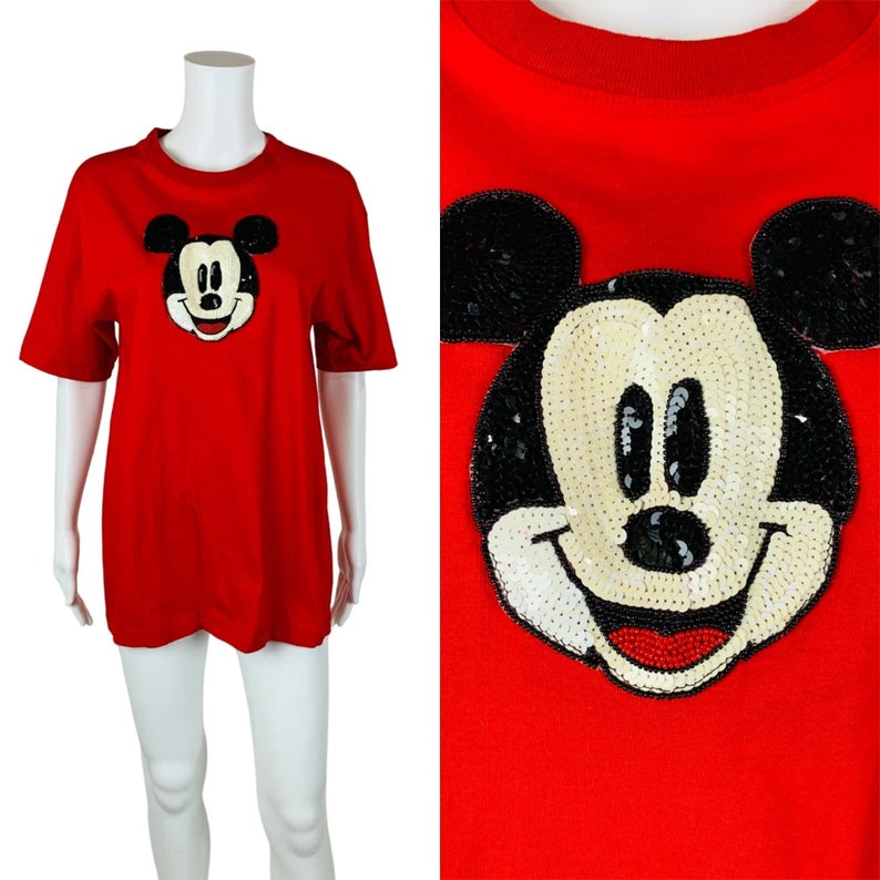May include: Red short-sleeved t-shirt with a large sequined Mickey Mouse design on the front.
